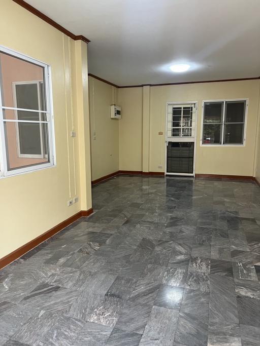 Spacious living room with gray tiled flooring and ample natural light