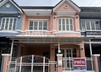 Two-story residential house with pink facade and security gate