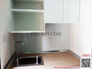 Compact kitchen space with stainless steel sink and wall-mounted shelving