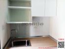 Compact kitchen space with stainless steel sink and wall-mounted shelving