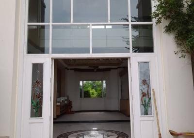 Elegant double-height entrance of a building with glass doors and a chandelier