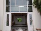 Elegant double-height entrance of a building with glass doors and a chandelier