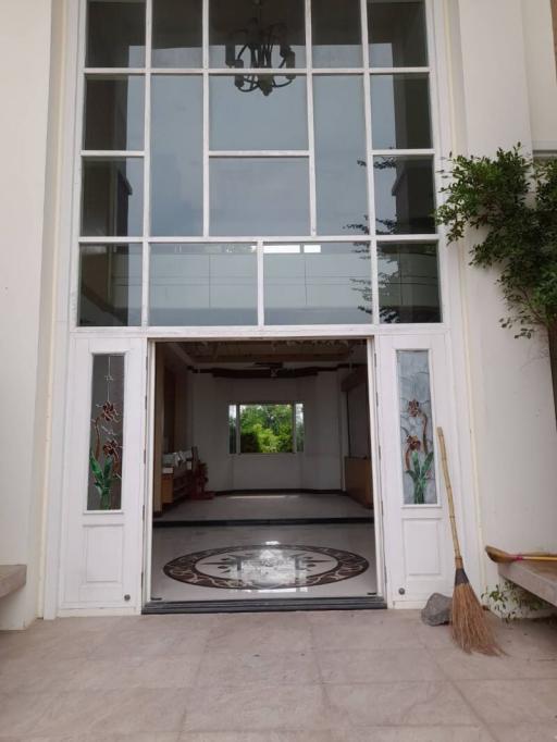 Elegant double-height entrance of a building with glass doors and a chandelier