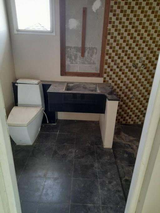 Unfinished bathroom with toilet and vanity under construction