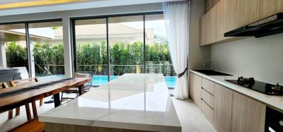 Modern kitchen with large island, natural light, and pool view
