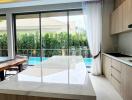 Modern kitchen with large island, natural light, and pool view