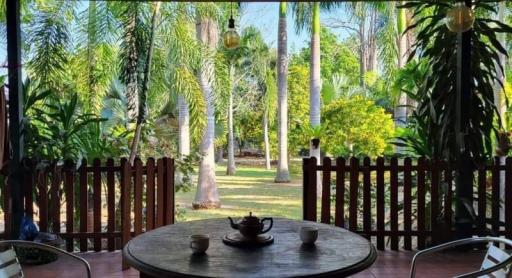 Cozy patio with a wooden table and chairs overlooking a serene garden