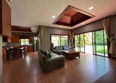 Spacious living room with large windows and an open kitchen layout