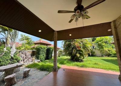 Spacious covered patio with ceiling fan and garden view