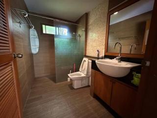Modern bathroom with a glass shower area, wooden floor, and a vessel sink