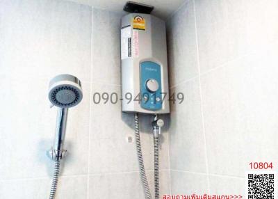 Electric shower head with heater and hand shower in a tiled bathroom