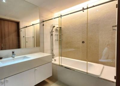 Modern bathroom with glass shower division and wooden accents