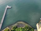 Aerial view of waterfront property with pier and natural surroundings