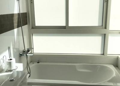 Bright bathroom with large window and bathtub