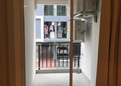 View of the balcony from inside the apartment showing railing and adjacent buildings