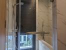 Modern bathroom with a glass shower stall and marble walls