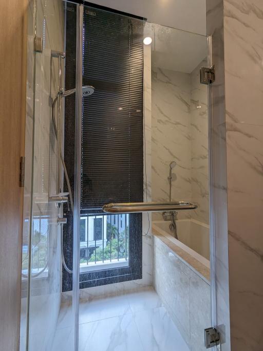 Modern bathroom with a glass shower stall and marble walls