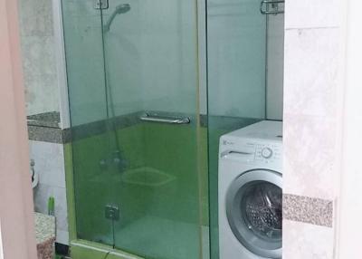 Modern bathroom with a glass shower enclosure and built-in washing machine