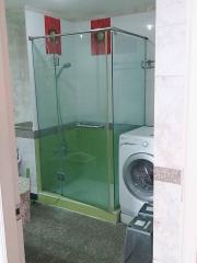 Modern bathroom with a glass shower enclosure and built-in washing machine