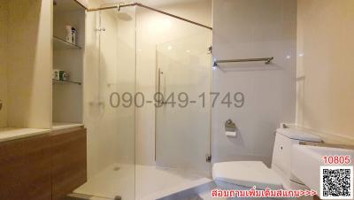 Modern bathroom with transparent shower cabin, bathtub, toilet, and towel rack