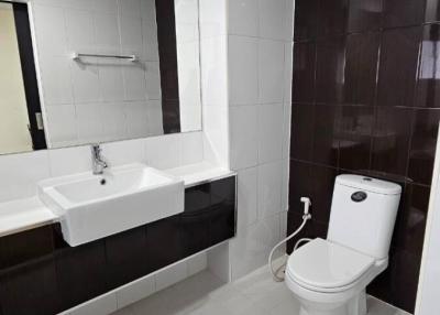 Modern bathroom interior with white fixtures and dark tiles