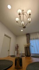 Contemporary dining area with elegant chandelier and decorative plants