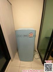 Compact blue refrigerator in a narrow utility space