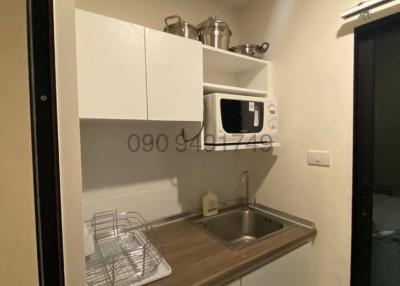 Compact modern kitchen with white cabinets and stainless steel sink