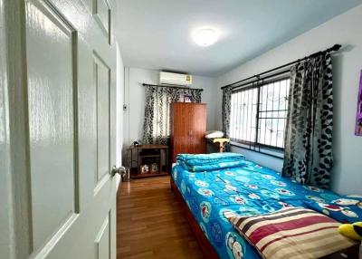 Cozy bedroom with natural light and wooden flooring