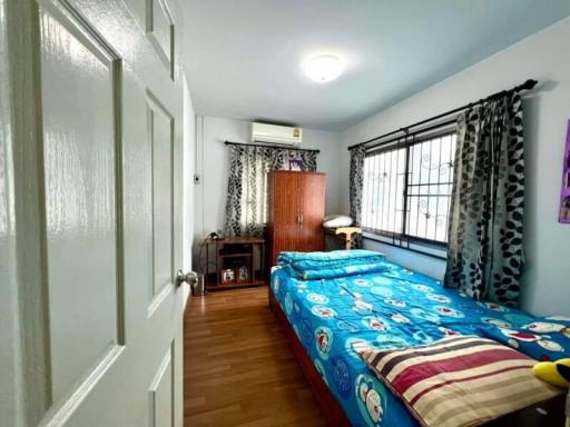 Cozy bedroom with natural light and wooden flooring