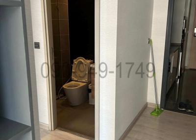 Modern bathroom viewed from a hallway with glass door entrance