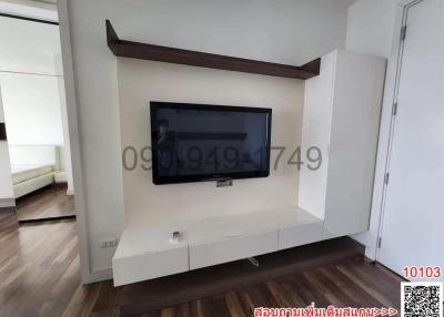 Modern living room with wall-mounted television and white storage cabinets