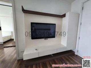 Modern living room with wall-mounted television and white storage cabinets