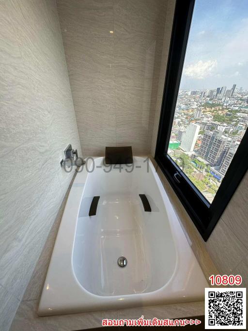 Modern bathroom with city view through a large window