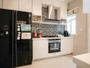 Modern kitchen with stainless steel appliances and mosaic backsplash