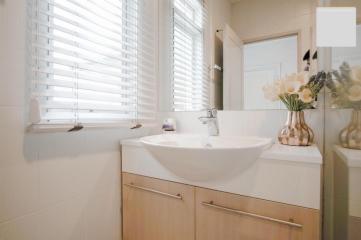 Bright clean bathroom with modern sink and flowers