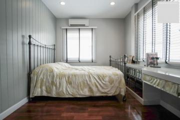 Cozy bedroom with wooden flooring and natural light