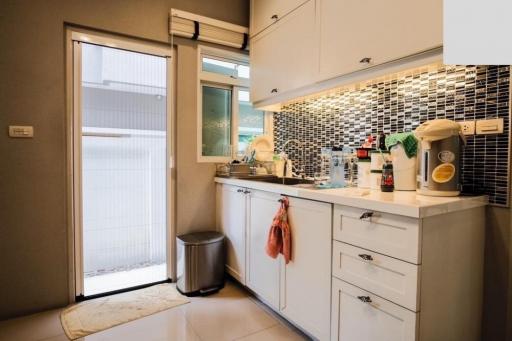 Modern kitchen with mosaic backsplash and white cabinetry