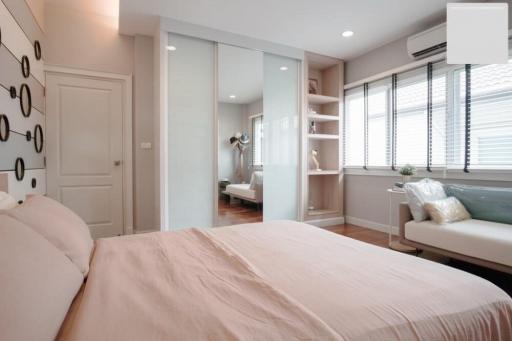 Modern bedroom with expansive shelving and ample natural light