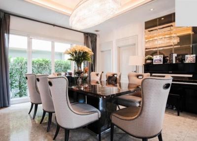 Elegant dining room with chandelier lighting and grand piano