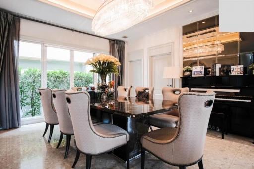 Elegant dining room with chandelier lighting and grand piano