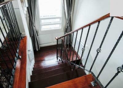 Elegant wooden staircase with wrought iron railings in a bright interior