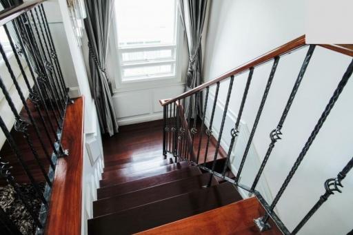 Elegant wooden staircase with wrought iron railings in a bright interior