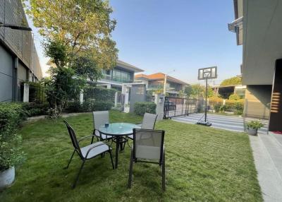 Spacious backyard with lawn and patio furniture near residential buildings