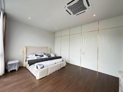 Spacious modern bedroom with a large bed and glossy wardrobe