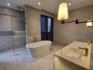 Modern bathroom with freestanding tub, walk-in shower, and double sink