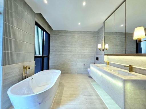 Modern bathroom with standalone bathtub, dual sinks, and elegant lighting