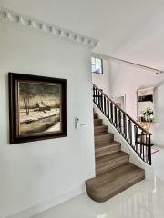 Elegant staircase with a framed painting in a well-lit space