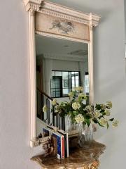 Elegant interior with ornate mirror over a marble console table with decorative items