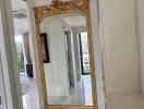 Elegant corridor with a large ornamental mirror and white marble flooring